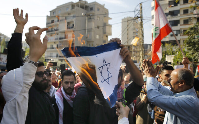 A few dozen people demonstrate and chant slogans as they burn a representation of an Israeli flag during a protest near the U.S. embassy in Aukar, northeast of Beirut, Lebanon, Sunday, November 24, 2019. (AP/Bilal Hussein) A few dozen people demonstrate and chant slogans as they burn a representation of an Israeli flag during a protest near the U.S. embassy in Aukar, northeast of Beirut, Lebanon, Sunday, November 24, 2019. (AP/Bilal Hussein)