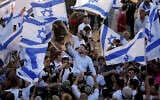 File: MK Bezalel Smotrich, center, waves an Israeli flag during the annual 'Flags March' next to Damascus Gate, outside Jerusalem's Old City, June 15, 2021. (AP Photo/Mahmoud Illean)