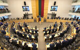 Members of Lithuanian parliament give Ukraine President Volodymyr Zelensky a standing ovation before he speaks in a virtual address to Lithuanian parliament in Vilnius, Lithuania, Tuesday, April 12, 2022.(AP Photo/Mindaugas Kulbis)