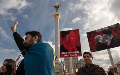 Iranians in Ukraine hold placards showing Russian President Vladimir Putin and Iran’s Supreme Leader Ayatollah Ali Khamenei, as they protest against regimes in Moscow and Tehran, which have apparently stepped up defense ties amid Russia's war against Ukraine, in Kyiv, Ukraine, October 28, 2022. (AP/Andrew Kravchenko)