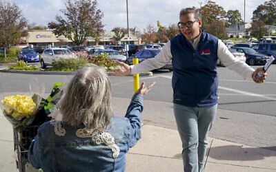 Republican candidate for New York's 3rd Congressional District George Santos, right, talks to a voter while campaigning outside a Stop and Shop store, November 5, 2022, in Glen Cove, New York. (AP/Mary Altaffer)