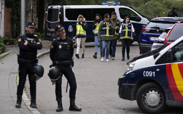 Police officers stand guard as other officers in yellow vests walk back at the cordoned off area next to the Ukrainian embassy in Madrid, Spain, Wednesday, Nov. 30, 2022. (AP Photo/Paul White) Police officers stand guard as other officers in yellow vests walk back at the cordoned off area next to the Ukrainian embassy in Madrid, Spain, Wednesday, Nov. 30, 2022. (AP Photo/Paul White)