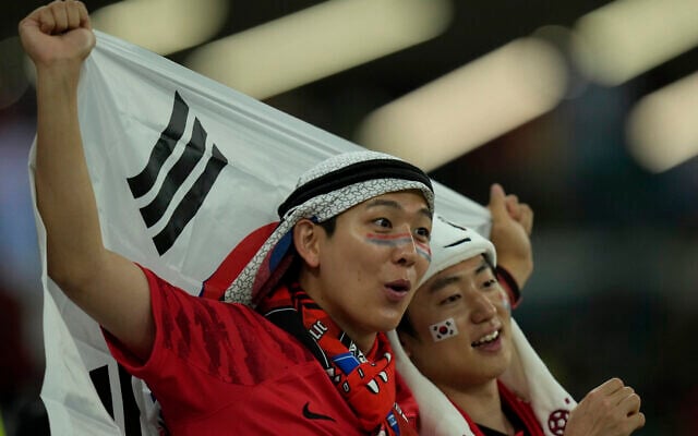 FILE - Soccer fans await the start of the World Cup group H soccer match between South Korea and Portugal, at the Education City Stadium in Al Rayyan , Qatar, Friday, Dec. 2, 2022.  At a World Cup that has become a political lightning rod, it comes as no surprise that soccer fans’ sartorial style has sparked controversy. At the first World Cup in the Middle East, fans from around the world have refashioned traditional Gulf Arab headdresses and thobes. (AP Photo/Francisco Seco, File)