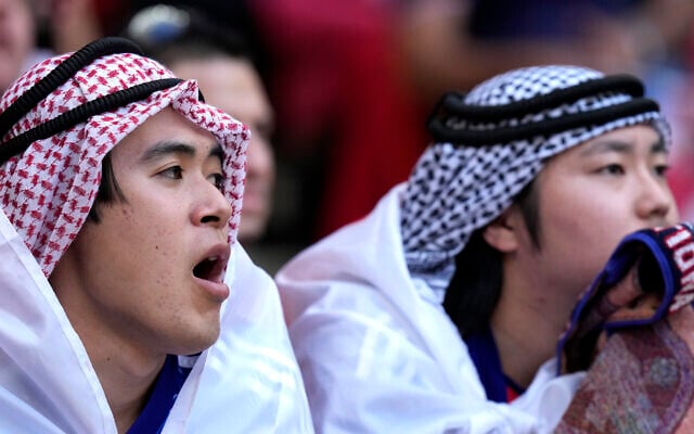 FILE - Fans watch the World Cup, group E soccer match between Japan and Costa Rica, at the Ahmad Bin Ali Stadium in Al Rayyan , Qatar, Sunday, Nov. 27, 2022.  At a World Cup that has become a political lightning rod, it comes as no surprise that soccer fans’ sartorial style has sparked controversy. At the first World Cup in the Middle East, fans from around the world have refashioned traditional Gulf Arab headdresses and thobes.  (AP Photo/Darko Bandic, File)