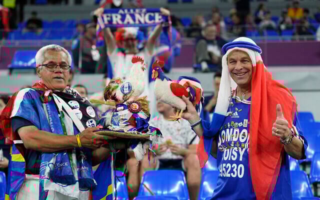 FILE - Fans of France cheer prior to the World Cup group D soccer match between France and Denmark at the Stadium 974 in Doha, Qatar, Saturday, Nov. 26, 2022.  At a World Cup that has become a political lightning rod, it comes as no surprise that soccer fans’ sartorial style has sparked controversy. At the first World Cup in the Middle East, fans from around the world have refashioned traditional Gulf Arab headdresses and thobes. (AP Photo/Martin Meissner, File)