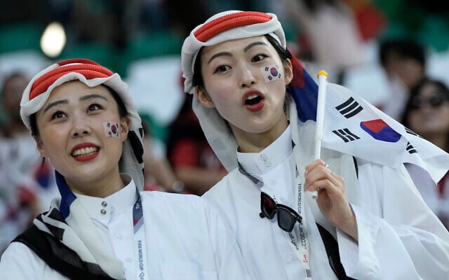 FILE - Fans cheer before the World Cup group H soccer match between South Korea and Portugal, at the Education City Stadium in Al Rayyan , Qatar, Friday, Dec. 2, 2022.  At a World Cup that has become a political lightning rod, it comes as no surprise that soccer fans’ sartorial style has sparked controversy. At the first World Cup in the Middle East, fans from around the world have refashioned traditional Gulf Arab headdresses and thobes. (AP Photo/Hassan Ammar, File)