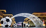 A woman walks in downtown Doha, Qatar, Monday, Dec. 5, 2022. (AP Photo/Natacha Pisarenko)