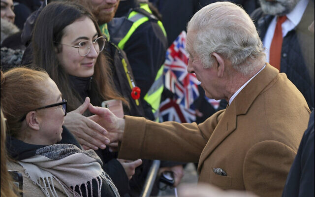 Britain's King Charles III, right, greets members of the public as he arrives for a visit to Luton Town Hall, where he is meeting community leaders and voluntary organisations, in Luton, England, Tuesday, Dec. 6, 2022. (Yui Mok/PA via AP)