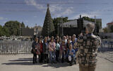 Tourists take pictures with the Christmas tree in Manger Square, adjacent to the Church of the Nativity in Bethlehem, Dec. 3, 2022. (AP Photo/ Mahmoud Illean)