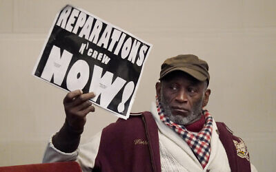 Illustrative -- Morris Griffin holds up a sign during a meeting by the Task Force to Study and Develop Reparation Proposals for African Americans in Oakland, California, December 14, 2022. (AP Photo/Jeff Chiu)