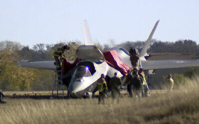 This image taken from video provided by KDFW, shows emergency personnel at the scene after a fighter jet crash landed at Naval Air Station Joint Reserve Base in Fort Worth, Texas, Thursday, Dec. 15, 2022. The pilot safely ejected from a plane after a failed landing. (KDFW via AP)