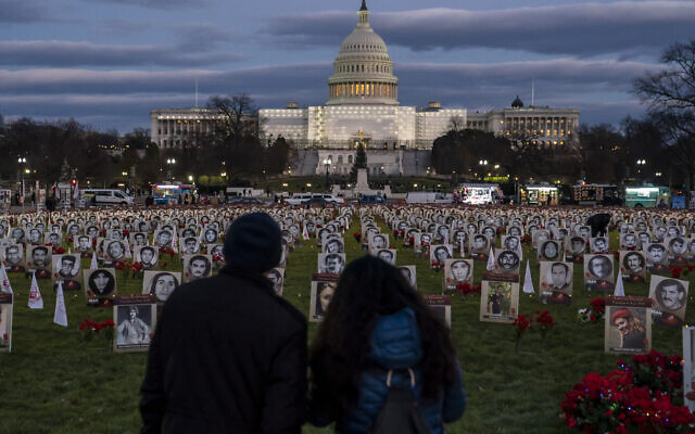 Protesters walk through a vigil honoring Iranians allegedly killed by their government during a rally in support of the ongoing protests in Iran at the National Mall on Dec. 17, 2022, in Washington. (AP Photo/Nathan Howard)