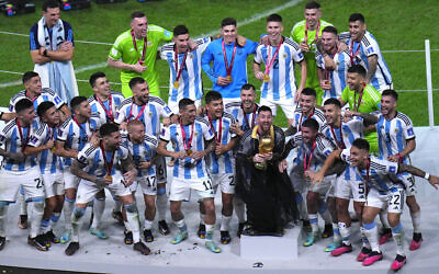 Argentina's Lionel Messi, draped in an Arab cloak, holds the trophy as he celebrates with his team at the end of the World Cup final soccer match between Argentina and France at the Lusail Stadium in Lusail, Qatar, Sunday, Dec. 18, 2022. Argentina won 4-2 in a penalty shootout after the match ended tied 3-3. (AP Photo/Hassan Ammar)