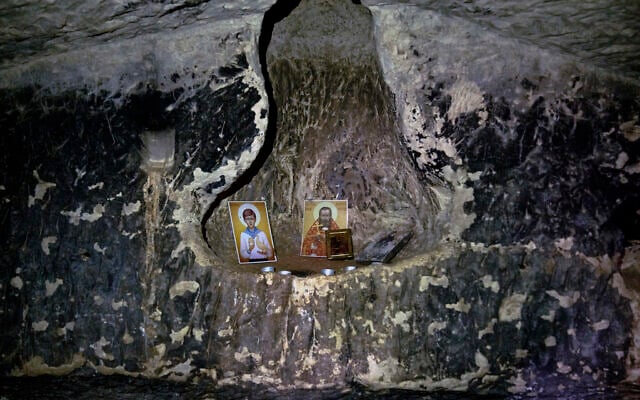 Religious icons left by prior visitors are seen inside a 2,000-year-old Second Temple-Period burial cave designated the Salome Cave that was recently uncovered in the Lachish Forest in Israel, December 20, 2022. (AP Photo/ Maya Alleruzzo)