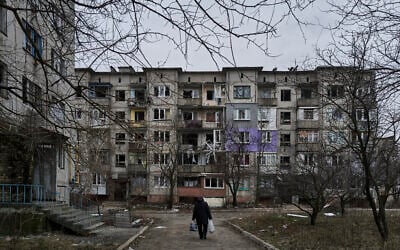 A civilian walks among heavily damaged residential buildings in Soledar, Donetsk region, Ukraine, December 21, 2022. (AP Photo/Libkos)