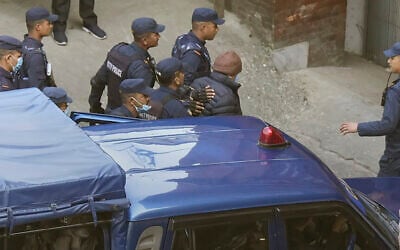 Nepalese police escort Charles Sobhraj, in brown cap, to the immigration office, in Kathmandu, Nepal, Friday, Dec. 23, 2022.  (AP Photo/Niranjan Shrestha)