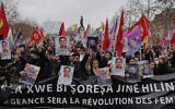 Kurdish activist and anti-racism groups stage a protest holding Kurdistan Workers Party, PKK, flag and pictures of the recent victims of a shooting at the Kurdish culture center in Paris, December 24, 2022. (AP Photo/Lewis Joly)
