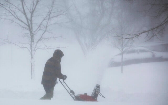 A person clears snow as a winter storm rolls through Western New York on, December 24, 2022, in Amherst, New York. (AP Photo/Jeffrey T. Barnes) A person clears snow as a winter storm rolls through Western New York on, December 24, 2022, in Amherst, New York. (AP Photo/Jeffrey T. Barnes)