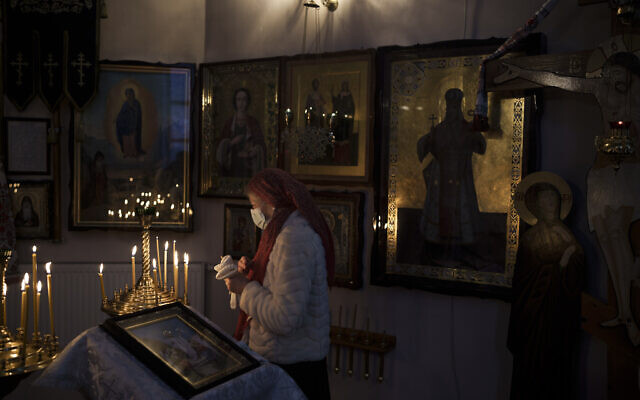 A woman attends a Christmas mass at an Orthodox Church in Bobrytsia, outskirts of Kyiv, Ukraine, Dec. 25, 2022. (AP Photo/Felipe Dana)