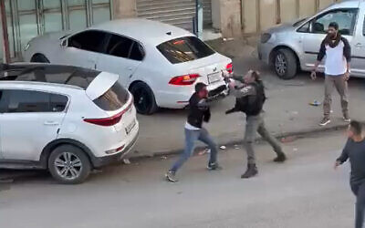A Border Police officer seeks to apprehend a Palestinian stabbing suspect in the northern West Bank town of Huwara on December 2, 2022. (Screen capture/Twitter)