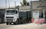 Palestinian trucks loaded with aggregate, iron and cement enter through the Kerem Shalom commercial crossing in  the southern Gaza Strip, on September 1, 2021. (Abed Rahim Khatib/Flash90)