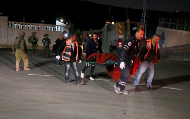 Palestinian medics carry the body of Mojahed al-Najjar, who was shot dead by Israeli security forces after allegedly carrying out a shooting attack on an army post near Ofra in the West Bank, December 7, 2022. (Flash90) Palestinian medics carry the body of Mojahed al-Najjar, who was shot dead by Israeli security forces after allegedly carrying out a shooting attack on an army post near Ofra in the West Bank, December 7, 2022. (Flash90)