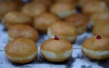 Illustrative: Fresh Hanukkah doughnuts, or sufganiyot, prepared days ahead of the eight-night festival at the Alon Conditory in Kiryat Shmona, northern Israel, December 14, 2022. (Ayal Margolin/Flash90)