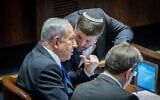 Likud leader MK Benjamin Netanyahu (left) speaks with Religious Zionism party head MK Bezalel Smotrich during a vote in the Knesset, December 20, 2022. (Yonatan Sindel/Flash90)