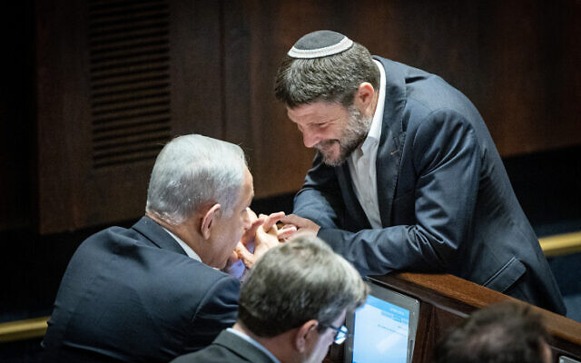 Religious Zionism party head MK Bezalel Smotrich (right) speaks with Likud leader Benjamin Netanyahu during a vote in the Knesset on December 20, 2022. (Yonatan Sindel/Flash90) Religious Zionism party head MK Bezalel Smotrich (right) speaks with Likud leader Benjamin Netanyahu during a vote in the Knesset on December 20, 2022. (Yonatan Sindel/Flash90)
