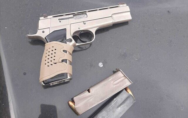 A hand gun and magazine found on a Palestinian terror suspect during an arrest operation in the West Bank on December 14, 2022 (Israel Police) A hand gun and magazine found on a Palestinian terror suspect during an arrest operation in the West Bank on December 14, 2022 (Israel Police)