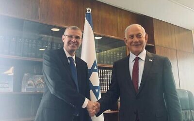Likud MK Yariv Levin (left) shakes hands with incoming prime minister Benjamin Netanyahu after being picked as the next government's justice minister, December 28, 2022. (Likud)
