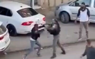A Border Police officer seeks to apprehend a Palestinian stabbing suspect in the northern West Bank town of Huwara on December 2, 2022. (Screen capture/Twitter)