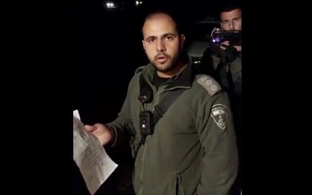 A Border Police officer serves Eilisha Yered, the spokesman of an Otzma Yehudit MK, with an eviction order from his home at the illegal West Bank outpost Ramat Migron, hours after the new government is sworn in, December 29, 2022 (Screenshot via Twitter; used in accordance with clause 27a of the Copyright Law) A Border Police officer serves Eilisha Yered, the spokesman of an Otzma Yehudit MK, with an eviction order from his home at the illegal West Bank outpost Ramat Migron, hours after the new government is sworn in, December 29, 2022 (Screenshot via Twitter; used in accordance with clause 27a of the Copyright Law)