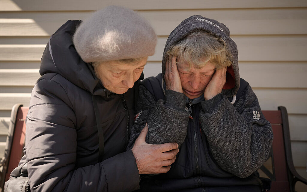 A neighbor comforts Natalia Vlasenko, whose husband, Pavlo Vlasenko, and grandson, Dmytro Chaplyhin, were killed by Russian forces, as she cries in her garden in Bucha, Ukraine, April 4, 2022. (AP Photo/Vadim Ghirda, File) A neighbor comforts Natalia Vlasenko, whose husband, Pavlo Vlasenko, and grandson, Dmytro Chaplyhin, were killed by Russian forces, as she cries in her garden in Bucha, Ukraine, April 4, 2022. (AP Photo/Vadim Ghirda, File)