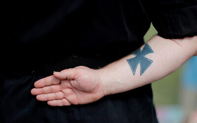 A neo-Nazi with an iron cross tattoo attends a rally in Newnan, Georgia, April 21, 2018. (AP Photo/David Goldman)