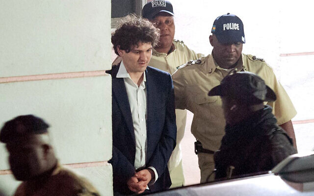 Illustrative: FTX founder Sam Bankman-Fried is led away in handcuffs by officers of the Royal Bahamas Police Force in Nassau, Bahamas on December 13, 2022. (Mario Duncanson/AFP) Illustrative: FTX founder Sam Bankman-Fried is led away in handcuffs by officers of the Royal Bahamas Police Force in Nassau, Bahamas on December 13, 2022. (Mario Duncanson/AFP)