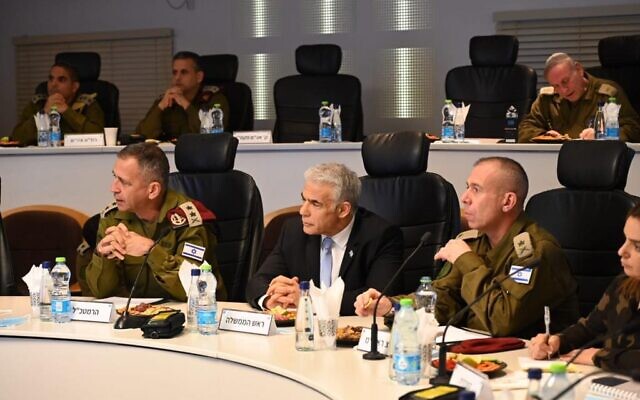 Prime Minister Yair Lapid (center), IDF chief Aviv Kohavi (left), and Lapid's military secretary Avi Gil, are seen at the IDF's West Bank headquarters, December 4, 2022. (Haim Zach/GPO)