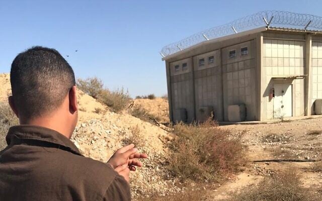 A detained Beoduin man points to an IDF storage bunker at the Sde Teiman base in southern Israel, after he and several others allegedly broke in and stole 30,000 bullets, during a crime reenactment, in an image published by police on December 20, 2022. (Israel Police) A detained Beoduin man points to an IDF storage bunker at the Sde Teiman base in southern Israel, after he and several others allegedly broke in and stole 30,000 bullets, during a crime reenactment, in an image published by police on December 20, 2022. (Israel Police)