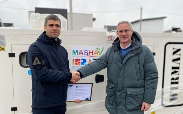 Israeli Ambassador to Ukraine Michael Brodsky (right) shakes hands with a Ukrainian official in front of a donated generator on December 20, 2022. (Israeli Embassy) Israeli Ambassador to Ukraine Michael Brodsky (right) shakes hands with a Ukrainian official in front of a donated generator on December 20, 2022. (Israeli Embassy)