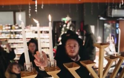 A Chabad man lights a menorah in Kharkiv, Ukraine, on the first night of Hanukkah, December 18, 2022 (courtesy Kharkiv Choral Synagogue)