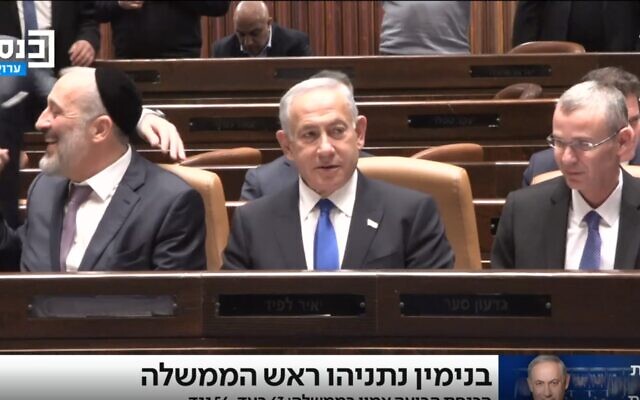 Prime Minister Benjamin Netanyahu takes his seat on the front bench of the Knesset, flanked by (left) Deputy Prime Minister and Interior Minister Aryeh Deri (Shas) and Justice Minister Yariv Levin, moments after parliament voted confidence in his new coalition, December 29, 2022 (Knesset channel screenshot) Prime Minister Benjamin Netanyahu takes his seat on the front bench of the Knesset, flanked by (left) Deputy Prime Minister and Interior Minister Aryeh Deri (Shas) and Justice Minister Yariv Levin, moments after parliament voted confidence in his new coalition, December 29, 2022 (Knesset channel screenshot)