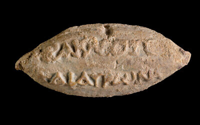 The names of the gods Heracles and Hauron on the reverse side of a
sling bullet found in Yavne. (Dafna Gazit/Israel Antiquities Authority) The names of the gods Heracles and Hauron on the reverse side of a
sling bullet found in Yavne. (Dafna Gazit/Israel Antiquities Authority)