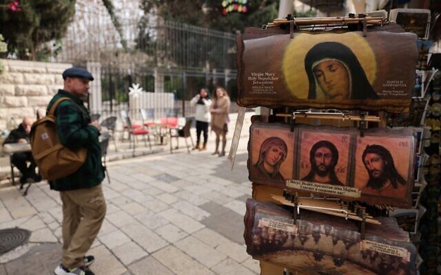 People walk past a shop in Jerusalem's Old City on January 1, 2023. (AHMAD GHARABLI / AFP)