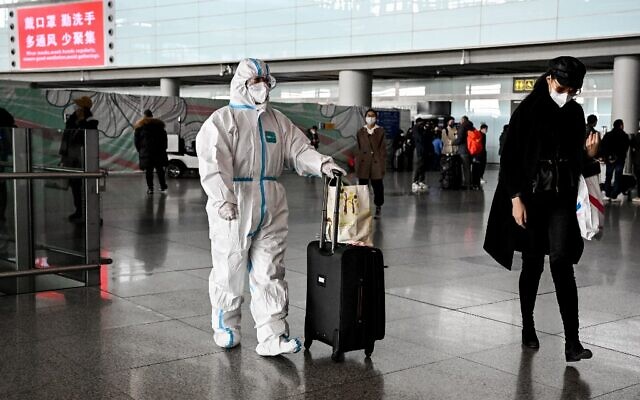 A passenger, wearing a personal protective equipment, walks at the arrival area at the Capital International Airport in Beijing on January 8, 2023. (Noel CELIS / AFP) A passenger, wearing a personal protective equipment, walks at the arrival area at the Capital International Airport in Beijing on January 8, 2023. (Noel CELIS / AFP)