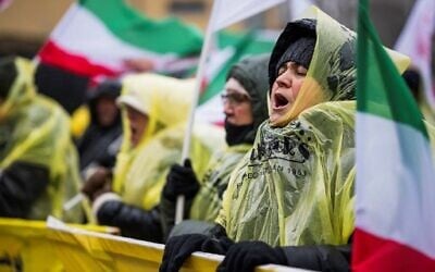 Protesters shout slogans and wave flags outside the Appeals Court building in Sollentuna, north of Stockholm, Sweden on January 11, 2023, at the start of the appeal trial of Hamid Noury, a former Iranian prison official, who has been sentenced to life imprisonment in Sweden for crimes committed during a 1988 purge of dissidents. (Jonathan NACKSTRAND / AFP)