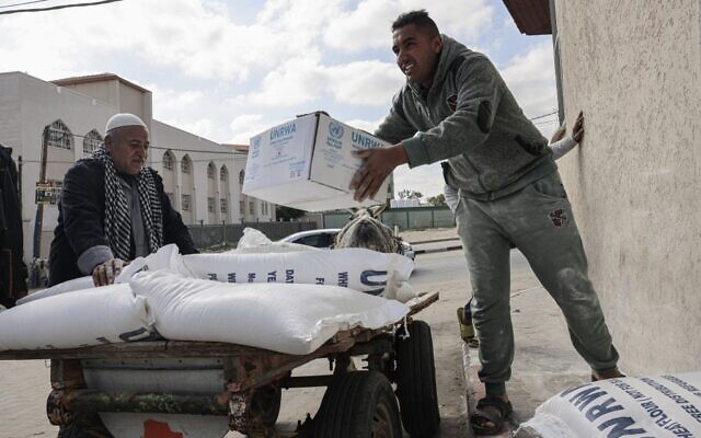 Palestinians carry bags of flour and other basic food products received as aid to poor families, at the United Nations Relief and Works Agency for Palestine Refugees (UNRWA) distribution center, in the Rafah refugee camp, southern Gaza Strip, on January 22, 2023. (SAID KHATIB / AFP) Palestinians carry bags of flour and other basic food products received as aid to poor families, at the United Nations Relief and Works Agency for Palestine Refugees (UNRWA) distribution center, in the Rafah refugee camp, southern Gaza Strip, on January 22, 2023. (SAID KHATIB / AFP)
