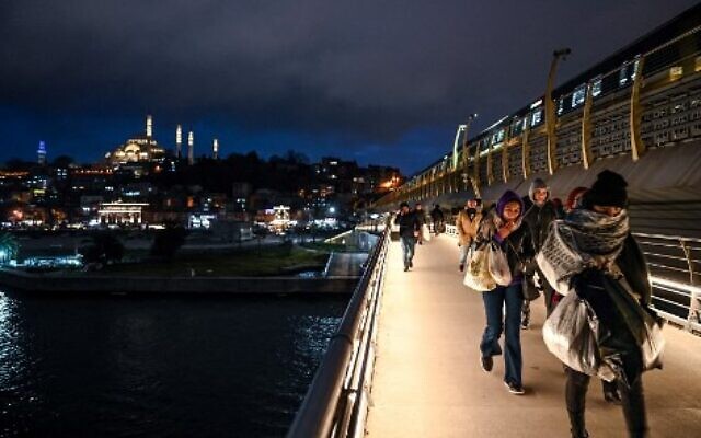 People walk on the Metro Bridge in Istanbul on January 24, 2023. (OZAN KOSE/AFP)