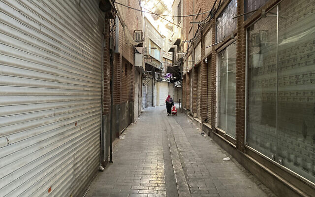 File: A woman carries her cart past closed shops of Tehran's Grand Bazaar, Iran amid strike calls, Nov. 15, 2022 (AP Photo/Vahid Salemi) File: A woman carries her cart past closed shops of Tehran's Grand Bazaar, Iran amid strike calls, Nov. 15, 2022 (AP Photo/Vahid Salemi)
