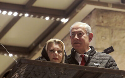 Prime Minister Benjamin Netanyahu, right, and his wife Sara Netanyahu, left, visit the Western Wall in the old city of Jerusalem, January 1, 2023. (Gil Cohen-Magen/Pool via AP)