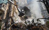 Firefighters work after a drone attack on buildings in Kyiv, Ukraine, October 17, 2022. (Roman Hrytsyna/AP)